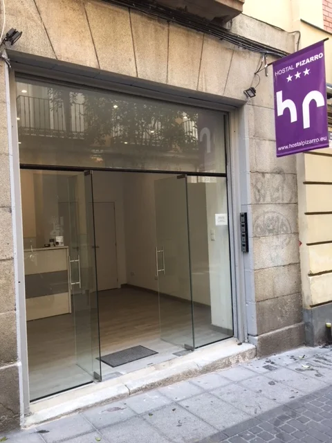 Hostal Pizarro facade with wide glass storefront