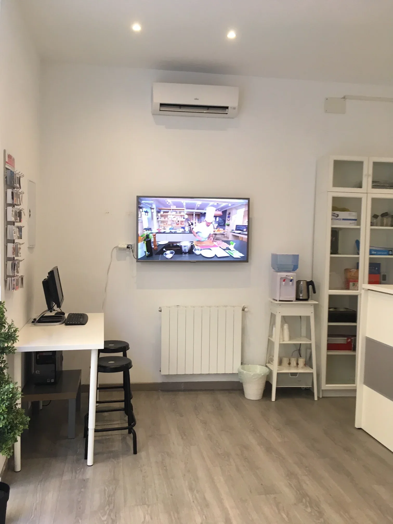 Modern minimalist reception area with wooden flooring and white walls