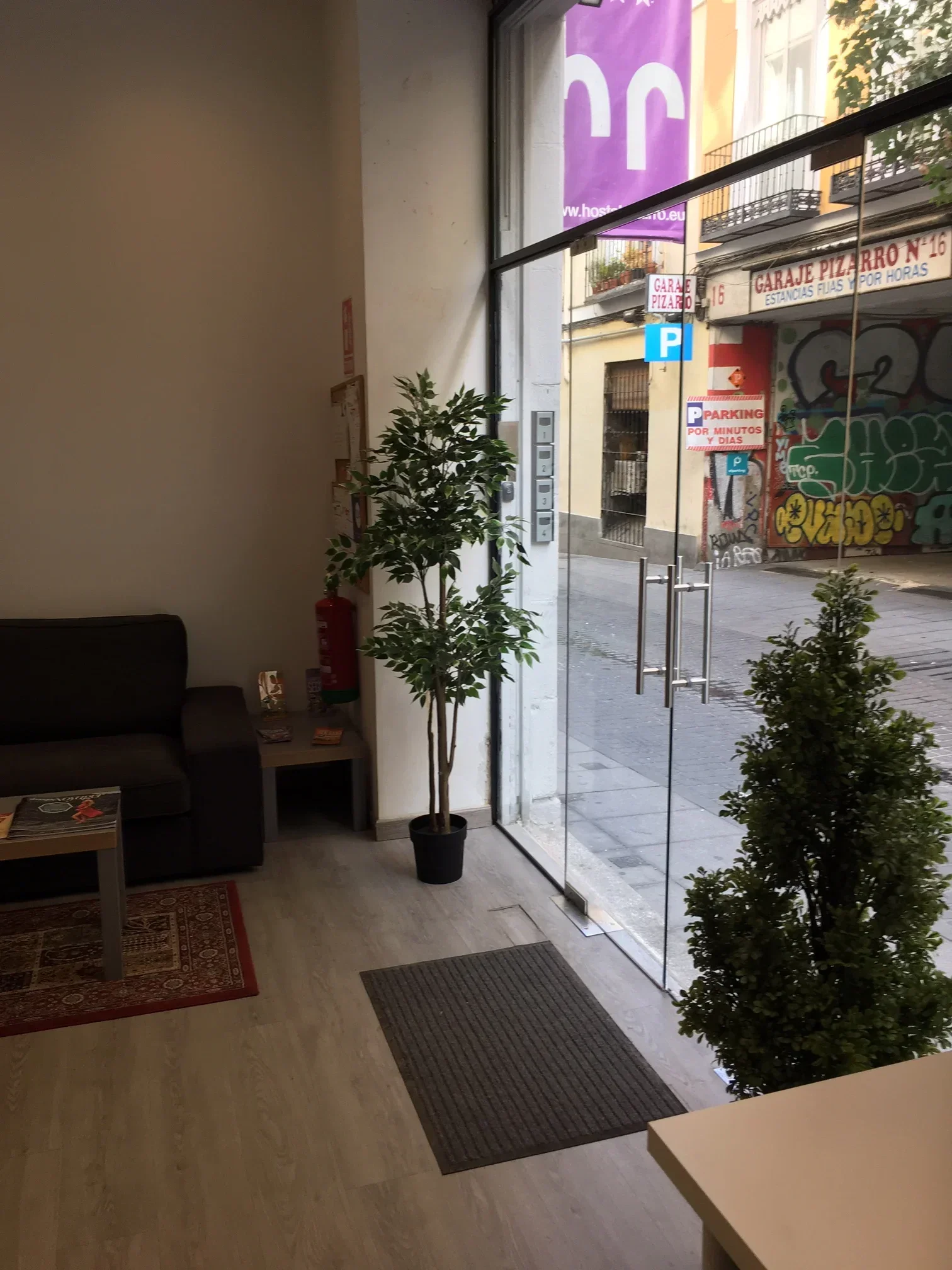 Modern reception entrance with glass door and narrow hallway