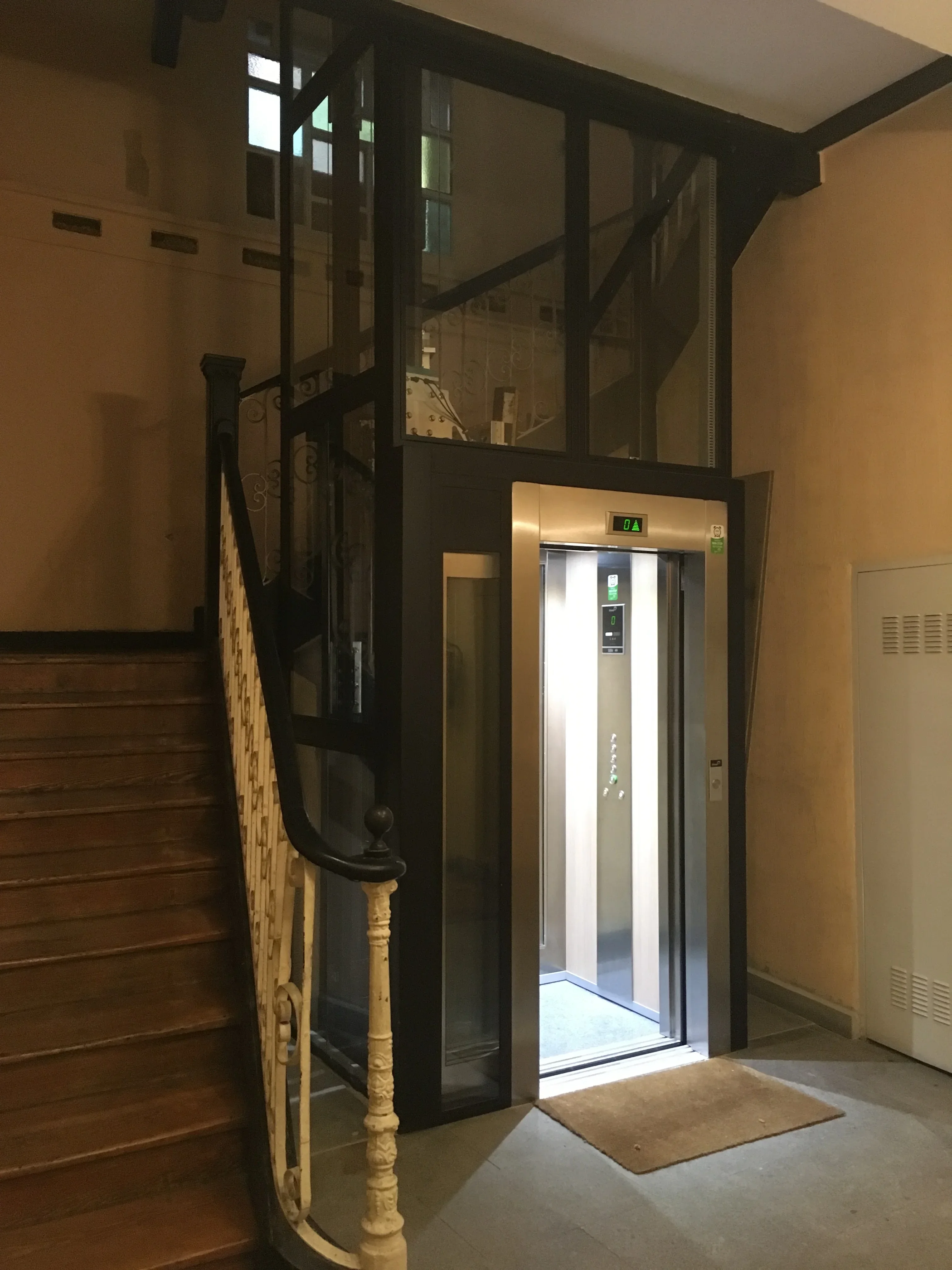 Modern elevator integrated within historic stairwell